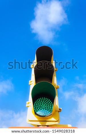 SEMAPHORE WITH GREEN LIGHT ON BLUE SKY WITH CLOUDS. STREET PHOTOGRAPHY