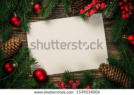 Christmas flat lay background with fir tree branch, present box and red decorations. Free space for design.