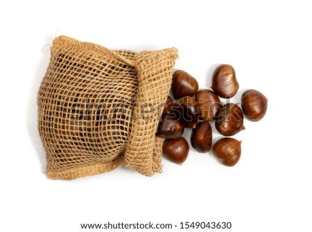Edible sweet chestnuts in burlap jute bag isolated top view. Healthy delicious autumn and christmas european veggie food