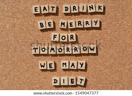 Eat, Drink, Be Merry For Tomorrow We May Diet, words in 3d wooden alphabet letters on a cork board background