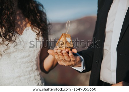 bride & groom with a little wooden house as a symbol of a new beginning