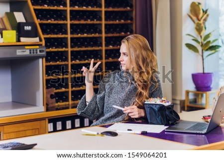 Portrait of smiling female interior designer sitting at office desk.
