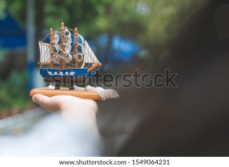 Hand holding model of a sailing ship