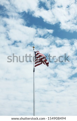American flag against bright sky with clouds