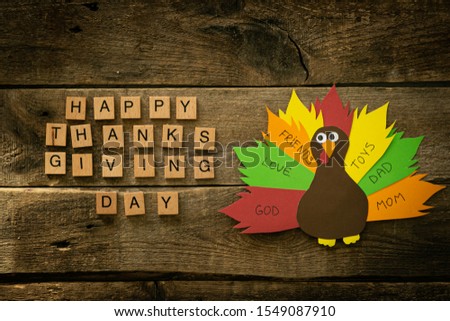 Thanksgiving paper craft - thanksful turkey on wood background, top view