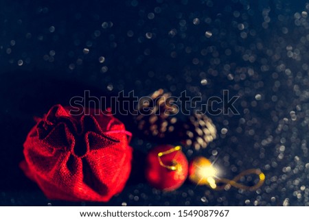 Christmas shiny black background. Red gift bag and Christmas toys.