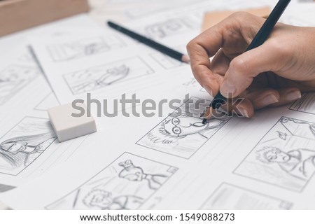 Hands draw a storyboard for the film.
