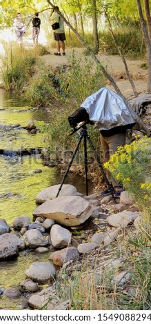 A well equipped photographer attempts to capture a moment along the Virgin River in Zion National Park, Utah, USA