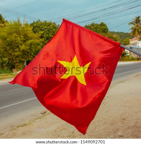 Vietnam flag flies in the wind on a city street