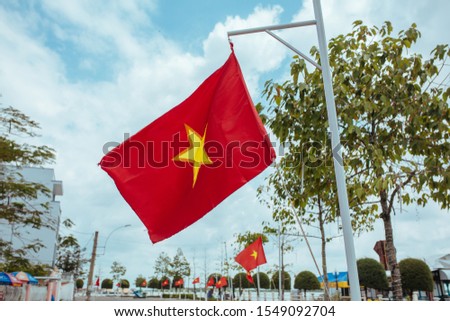 Vietnam flag flies in the wind on a city street