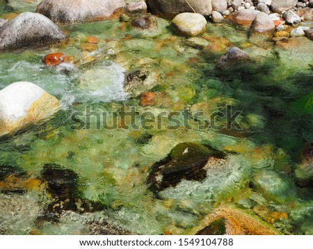 
clear mountain water straight from the stream  where the beautifull rocks and stones lay
