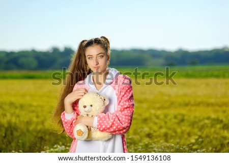 Cheerful girl in pajamas fooling around in the field