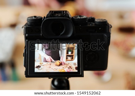 Young craftswoman in camera during video recording of home master class of making handmade soap