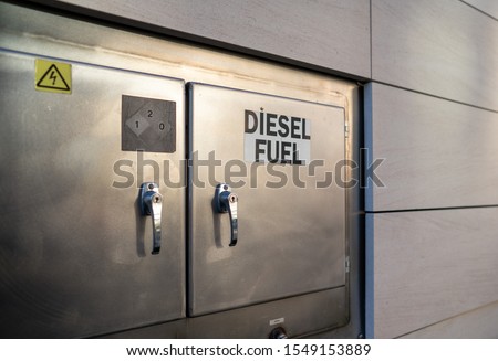 Diesel fuel sign on refueling station closed shut steel doors outside of building