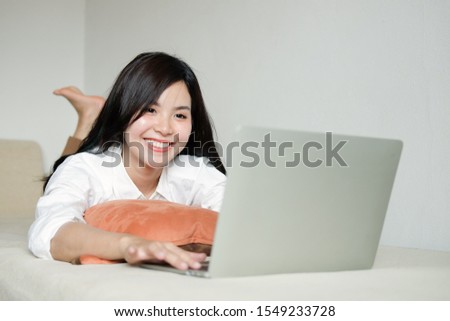 Woman relaxing on sofa in the living room enjoying sunny morning on the day Happy casual beautiful woman working on a laptop sitting in the house. 