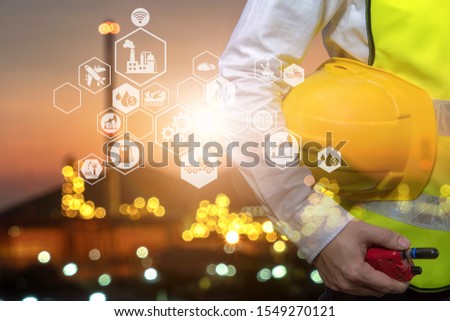 Engineer holding walkie talkie are working order at oil and gas refinery. Industry petrochemical concept image and icon connecting networking using technology.