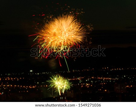 Bright colorful fireworks on the background of the night city. Fireworks on holiday in the twilight sky.