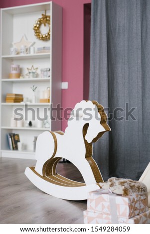 Rocking horse for children made of phoners and cardboard in a children's room decorated for Christmas or New Year