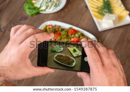 Smartphone photo of food.Mans hands make phone photography of Oriental traditional meals. lunch or dinner. For social media, blogging.  Healthy food