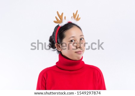 Image of cheerful young woman wearing christmas deer costume standing isolated over burgundy background wall. Looking at camera.