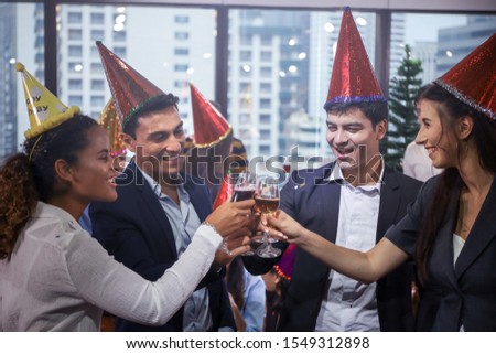 Business people or team or friend or colleague drinking a glass of champagne or alcohol in party after work, happy new year celebration fun in office
