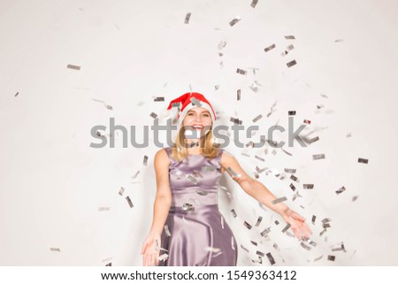 New year and holidays concept - Happy excited young woman in santa claus hat dancing and laughing over white background.