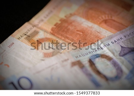 Two obsolete Belarusian banknotes of five and ten rubles on a dark background close-up. Retro style
