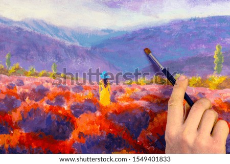 Artist hand with a brush closeup paints a beautiful picture paintntg artwork on canvas