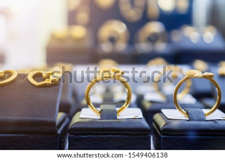 Jewelry golden rings earrings and necklaces show in luxury retail store window display showcase Royalty-Free Stock Photo #1549406138