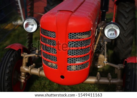Historic vintage red tractor on field