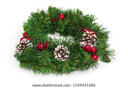 Christmas wreath made with artificial branches of Christmas tree, natural pine cones and decoration on a white background
