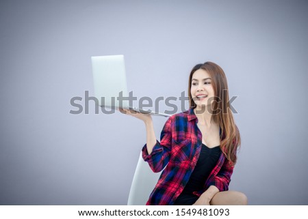 Laughing woman pointing finger on blank laptop computer screen isolated on a white 