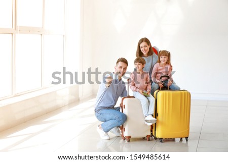 Happy family with luggage taking selfie in airport