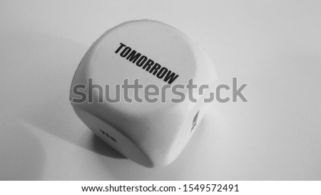 Anti stress big white foam candy with word "Tomorrow" on white table in black and white