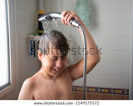 cute smiling boy washes in the bathroom.
