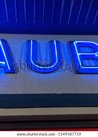 Blue neon letter U from old cinema sign