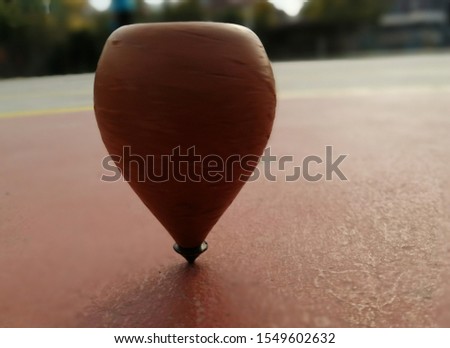 wooden spinning top while spinning on the ground