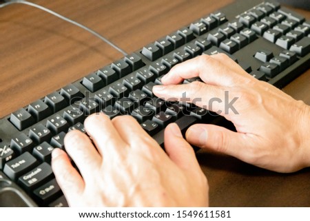 Working in the office. Typing on keyboard.