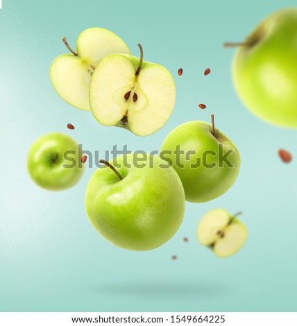 Flying fresh green apple with seeds on blue background. Creative levitation food, summer fruits Royalty-Free Stock Photo #1549664225