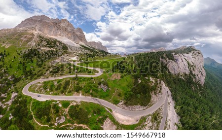 Aerial view of winding road surrounded by mountains, beautiful roads for traveling by motorcycle or car, the way of hikers and and cyclists, Falzarego Pass, Dolomites, Italy. Cortina d'Ampezzo.