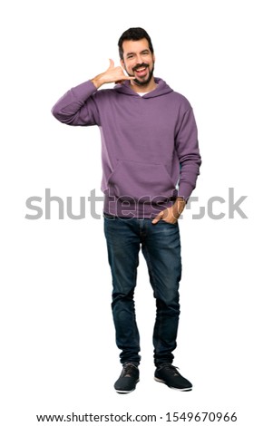 Full-length shot of Handsome man with sweatshirt making phone gesture. Call me back sign over isolated white background