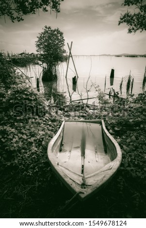 lLake view with boat. The wood boat on lake at sunset. Concept of loneliness, lacking direction, no leadership, rudderless, floating, listless or generally adrift without a goal. stillness calms Royalty-Free Stock Photo #1549678124