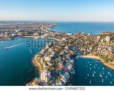 Aerial drone evening view of Manly, a beach-side suburb of northern Sydney in the state of New South Wales, Australia. Little Manly Beach in the foreground, Manly Harbour & Manly Beach in background.  Royalty-Free Stock Photo #1549687322