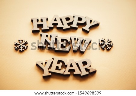 Happy New Year background.Rustic wooden letters on yellow decorative paper.Hand made home decor for winter holiday.