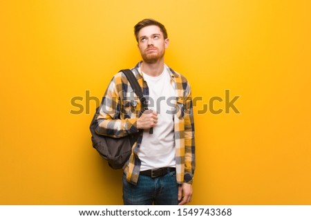Young redhead student man tired and bored