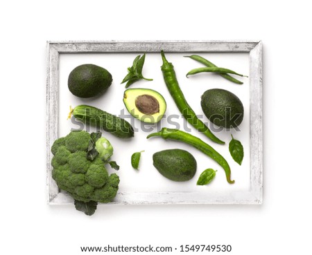 Organic concept. Green vegetables creating beautiful picture with frame on white background