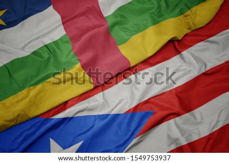 waving colorful flag of puerto rico and national flag of central african republic. macro