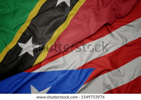 waving colorful flag of puerto rico and national flag of saint kitts and nevis. macro