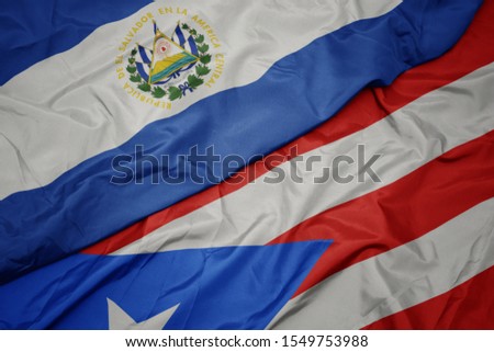 waving colorful flag of puerto rico and national flag of el salvador. macro