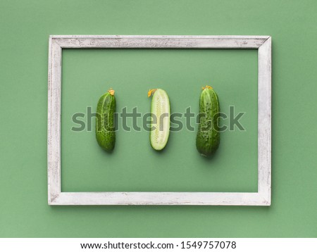 Creative card for vegans. Cucumbers out of frame on green background, copy space